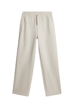 Beige träningsoveraller med en avslappnad passform, elastisk midja och dragsko. Har sidofickor och diskret branding på vänstra benet.