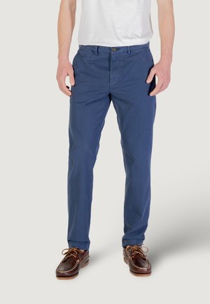 Chinos slim-fit di colore blu navy, realizzati in un tessuto misto cotone, con vita regolare e tasche frontali. Abbinati a scarpe da barca marroni.