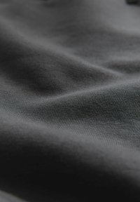 Dark gray fabric with a smooth, textured surface, showing subtle variations in shade and a slightly reflective finish.