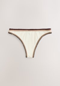 Bas de bikini blanc avec des coutures décoratives marron et noires le long des bords sur fond clair.