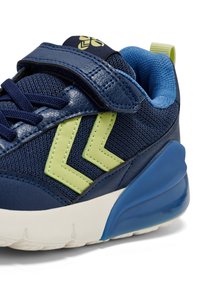 Baskets bleu marine avec une tige en mesh agrémentée d'accents verts, une bride à scratch et une semelle bleue rembourrée ; conçues pour le confort et le soutien.
