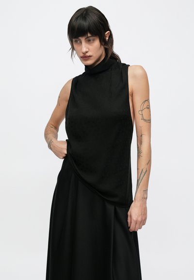 Černý top bez rukávů s vysokým límcem, zdobený strukturovaným vzorem. Látka působí hladce a elegantně se splývá.