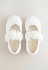 White ballet flats made of smooth satin with fabric flower accents on the strap. Soft, rounded toe design; inner logo and scalloped edging.