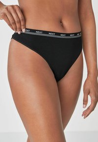 Zwarte katoen bikini met een contrasterende witte elastische tailleband met het "NEXT" logo en een gladde textuur. Ontworpen voor een comfortabele pasvorm.