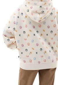 Sudadera de color crema con gráficos coloridos variados, incluyendo flores, símbolos de paz y logotipos. Cuenta con capucha con cordón y dobladillo acanalado.