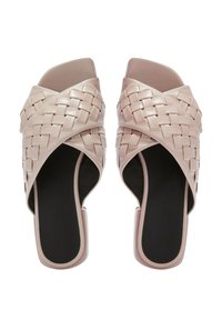 Sandali a scivolo intrecciati in rosa pastello con un ampio design a fascia incrociata e punta aperta, caratterizzati da una suola nera e una finitura liscia.
