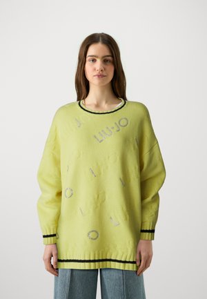Maglione giallo lavorato a maglia con design del logo in rilievo, colletto e polsini a coste neri e una vestibilità oversized. Tessuto morbido e testurizzato.