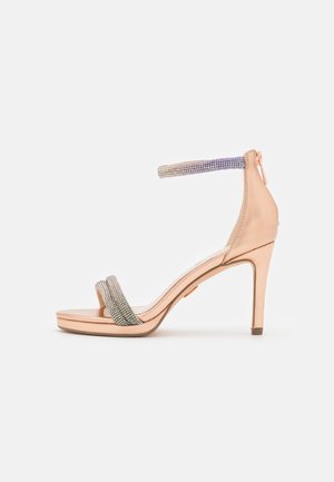 Roosa kuldne kõrge kontsaga sandaal siledast metallist viimistlusega, millel on kaks tekstureeritud rihma, mis on kaunistatud säravate kristallidega.