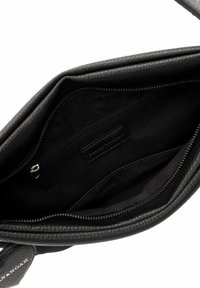 Black leather handbag interior with a textured finish, featuring a zippered pocket and a smooth fabric lining.