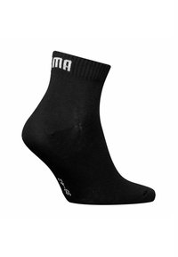 Schwarze Knöchelsohle aus glattem Material, mit einem gerippten Bündchen und weißer Markenstickerei oben. Dezente Struktur im gesamten Socken.