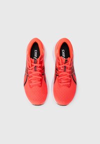 Red athletic shoes with a mesh upper, black accents, and laces. Cushioned sole and textured design for breathability and comfort.