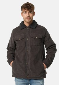 Donker corduroy jacket met een schapenvachtkraag, twee borstzakken en een knoopsluiting. Gelaagd stof met een stevige ontwerpm.