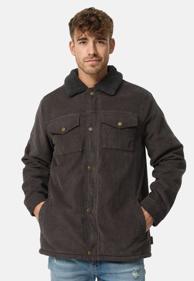 Donker corduroy jacket met een schapenvachtkraag, twee borstzakken en een knoopsluiting. Gelaagd stof met een stevige ontwerpm.