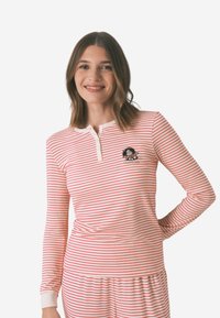Rød og hvid stribede langærmede top med henley-udskæring og et broderet tegneserie-design på brystet, lavet af blødt stof.