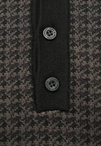 Πλεκτή ζακέτα με μοτίβο καρό σε μαύρους και καφέ τόνους, με μαύρο κουμπί και ριμπ κολλάρο.