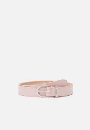 Lichtroze leren riem opgerold met zilveren afgeronde gesp en metalen lus gegraveerd met het Calvin Klein-logo op een witte achtergrond.