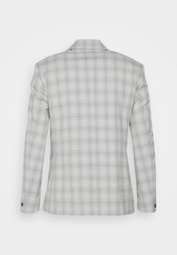 Blazer a scacchi grigio con un design strutturato, revers a becco e bottoni ai polsini. Il motivo include linee orizzontali e verticali.
