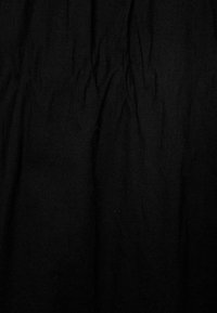 Černá tkanina s vrásčitou texturou, vyrobená z lehkého materiálu. Povrch je hladký bez viditelných vzorů nebo akcentů.