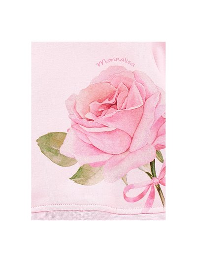 Lys rosa stoff har en stor, detaljert illustrasjon av en rosa rose med grønne blader og et rosa bånd. "Monnalisa" er trykt over blomsten.