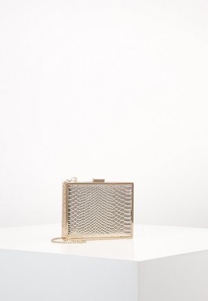 Rechteckige goldene Clutch mit strukturiertem Schlangenhautmuster und einem dünnen goldenen Kettenriemen auf weißer Oberfläche.