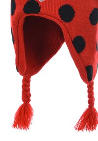 Red knitted hat with black polka dots, featuring braided tassels and ear flaps. Made from soft, textured yarn for warmth.