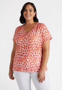 Haut à manches courtes et décolleté en V dans un motif abstrait orange et rose vibrant. Fabriqué en tissu léger avec une coupe décontractée pour le confort.
