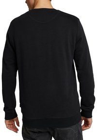 Sudadera negra de manga larga, con puños y dobladillo acanalados, hecha de un tejido suave, que presenta un diseño simple y clásico.