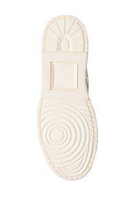Suola delle scarpe in gomma bianco sporco con texture circolari e accentuazione rettangolare. Ha un bordo scanalato e un pannello centrale liscio.