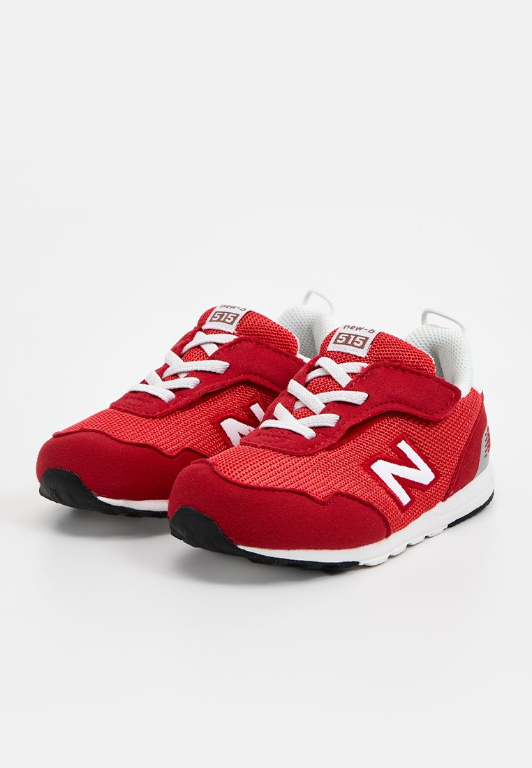 Czerwone buty sportowe wykonane z siateczki i zamszu, z białymi sznurowadłami, białym logo i czarną gumową podeszwą. Zaprojektowane z myślą o komforcie i wsparciu.