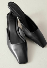 Zwarte leren slingback schoenen met een puntige, vierkante neus en een gladde textuur. Minimalistische stijl met een slanke silhouet.