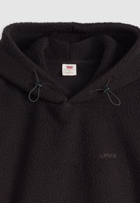 Sort fleece hættetrøje med struktureret overflade, justerbare snore og et lille Levi's logo. Løs pasform med hætte og blødt indvendigt for.