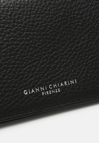 Borsa a tracolla in pelle nera con texture, caratterizzata dal logo in rilievo argento "GIANNI CHIARINI FIRENZE" sul fronte, design elegante e compatto.