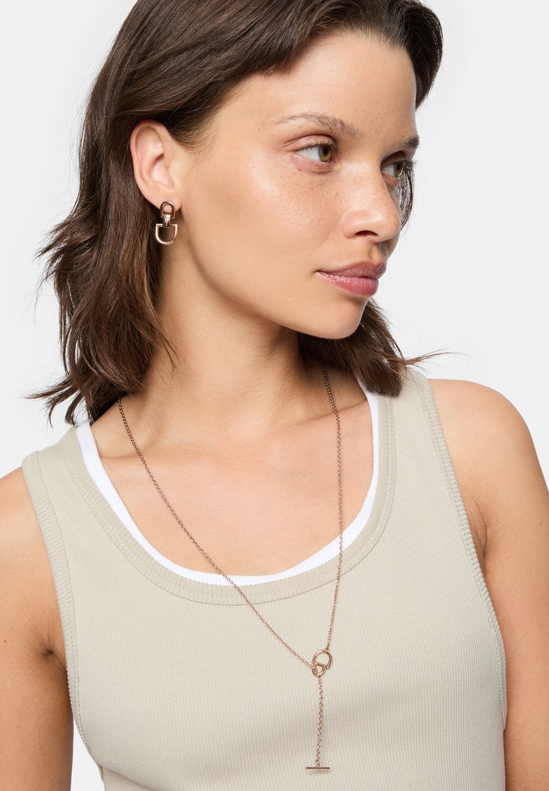 Rosenvergoldete Ohrringe mit einem kreisförmigen und U-förmigen Design, kombiniert mit einer langen, zarten rosengoldenen Halskette mit einem ovalen Akzent.