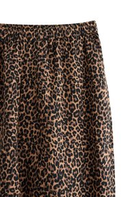 Ύφασμα με μοτίβο λεοπάρδαλης, καφέ φόντο με μαύρες βούλες. Ελαστική μέση στο πάνω μέρος. Το υλικό φαίνεται μαλακό και ελαφρύ.