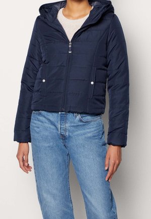 Navy quilted puffer jacket with a hood, front zipper, and two side pockets. Features horizontal stripes and a cropped design.