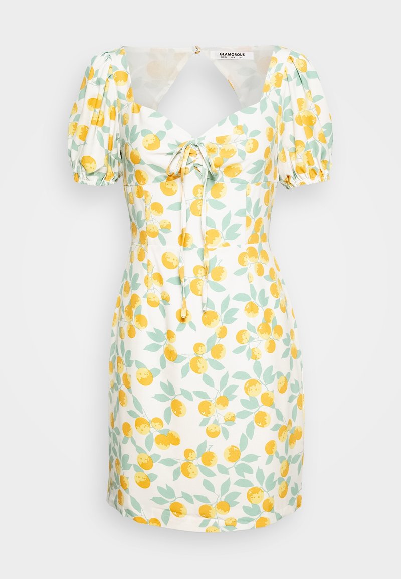 Robe florale avec des oranges jaunes et des feuilles vertes sur un fond blanc. Présente des manches bouffantes, un décolleté carré et une taille cintrée avec un lien.