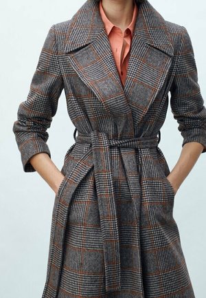 Grauer karierter Trenchcoat mit Gürtel, der einen großen Kragen, ausladende Ärmel und orangefarbene Akzente im Muster aufweist. Der Stoff wirkt strukturiert.
