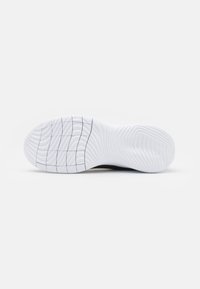 Semelle de chaussure blanche avec un motif de traction en vagues et en grille, présentée horizontalement sur un fond blanc uni.