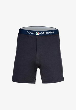 Bomullsboxer i mörk marinblå med elastisk midja som har "Dolce & Gabbana"-logotyp och italiensk flagga. Slät textur.