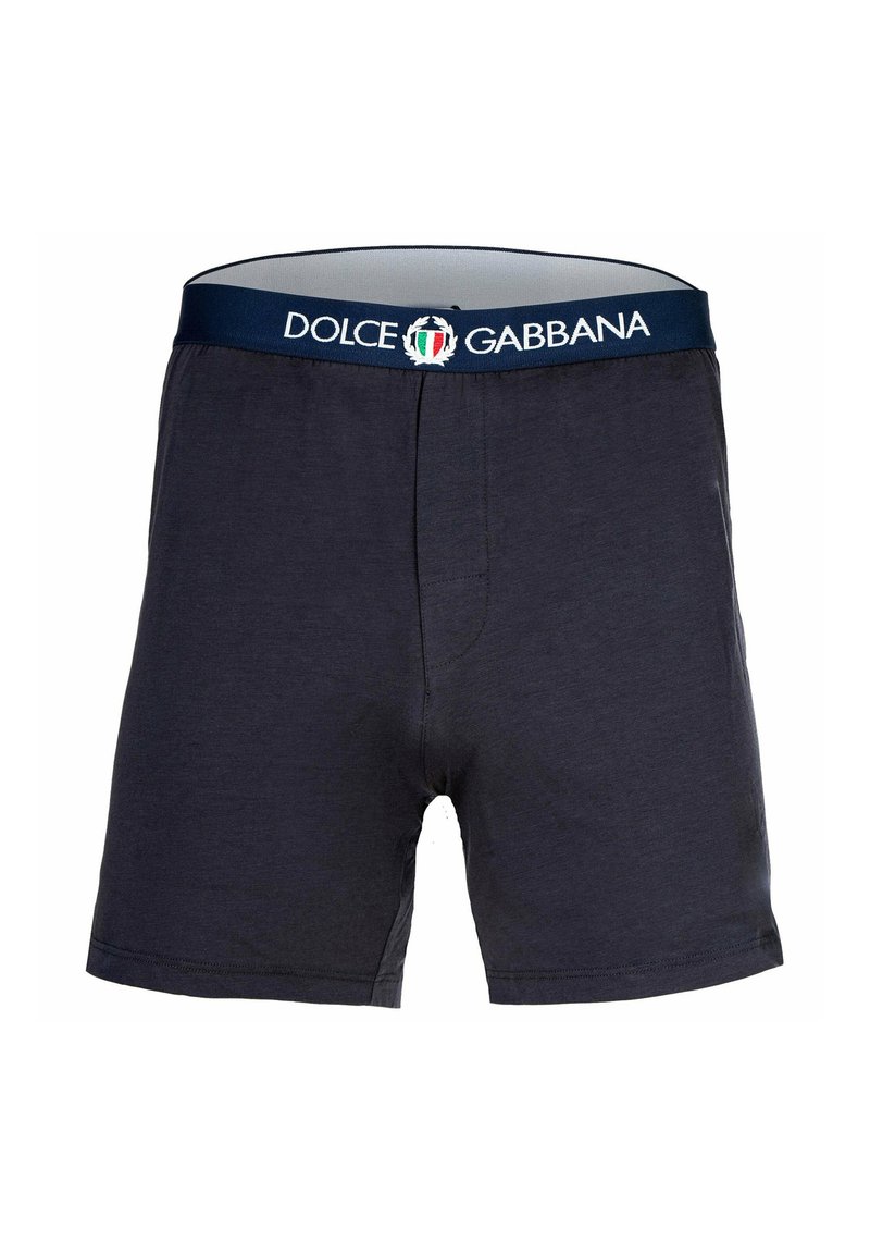 Bomullsboxer i mörk marinblå med elastisk midja som har "Dolce & Gabbana"-logotyp och italiensk flagga. Slät textur.