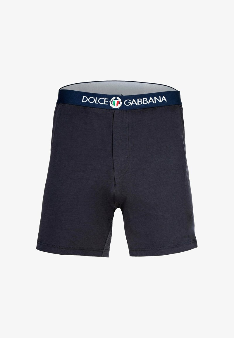 Bomullsboxer i mörk marinblå med elastisk midja som har "Dolce & Gabbana"-logotyp och italiensk flagga. Slät textur.
