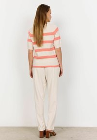 Lightweight knit top in beige with pink horizontal stripes, short sleeves, paired with beige wide-leg trousers and brown block-heel sandals.