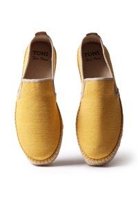 Espadrillas in tela gialla con una fascia elastica color nocciola, suola in juta e dettagli cuciti attorno al bordo. Design piatto con punta arrotondata.