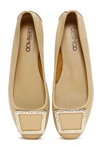 Ballerine in pelle beige con un accento in metallo quadrato martellato, punta arrotondata e suola piatta. Logo del brand visibile sulla soletta.