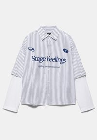 Cămașă cu dungi și mâneci scurte, cu nasturi, purtată peste o cămașă albă cu mâneci lungi, având inscripția "Stage Feelings" și imprimeuri grafice albastre pe piept.