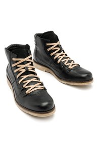 Czarne skórzane botki za kostkę z jasnobeżowym sznurowadłem, teksturowana powierzchnia, wyściełany kołnierz i gumowa podeszwa z kontrastującym jasnym brzegiem.