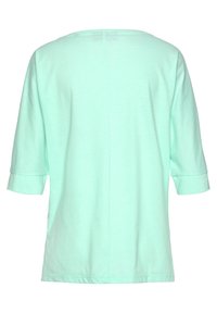 Light green short-sleeve top, made of soft fabric, features a relaxed fit, round neckline, and stitched detail along the back seam.