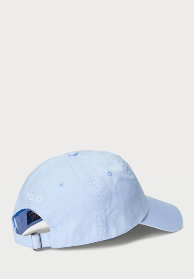 Svetlomodrá baseballová čiapka z bavlny s ohnutým hranom, nastaviteľný popruh na zadnej strane a vyšitým nápisom "POLO" v bielej farbe.