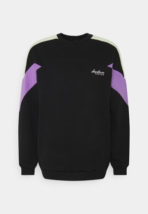 Sudadera negra de manga larga, con bloques de color verde, morado y negro. Logo de texto destacado en el frente. Textura suave.