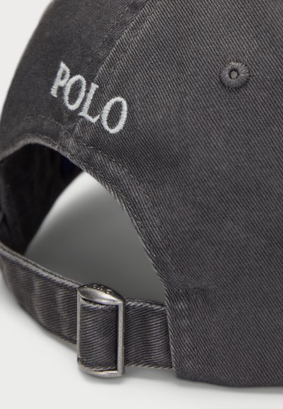 Must must cap, millel valge "POLO" tikand. Omab kõverat visiitkaarti ja reguleeritavat metallist luku tagaküljel, et sobida.